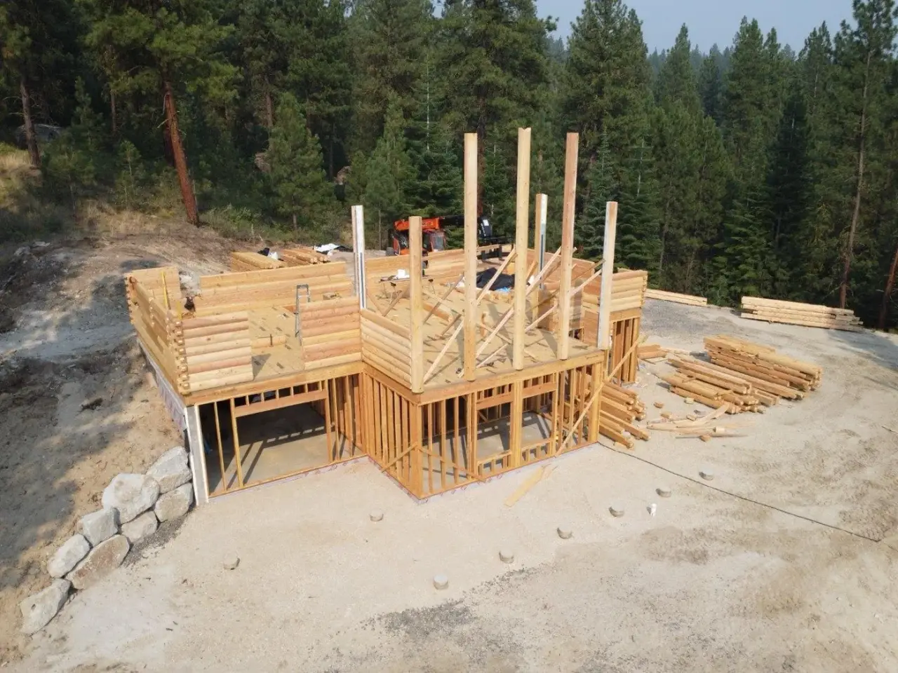 Log walls carrying the second floor deck, seen from the air.